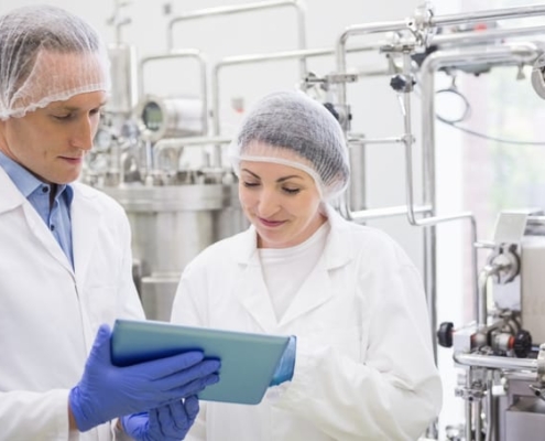 A food safety manager shows inspection logs to an auditor