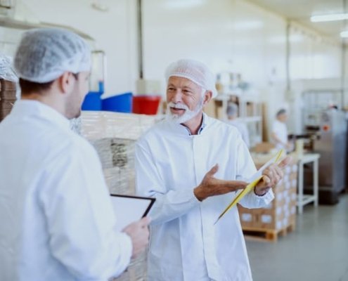 Two FSQA employees discuss food safety test results